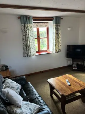 a living room with a couch and a coffee table at Tregatherall Barn in Boscastle