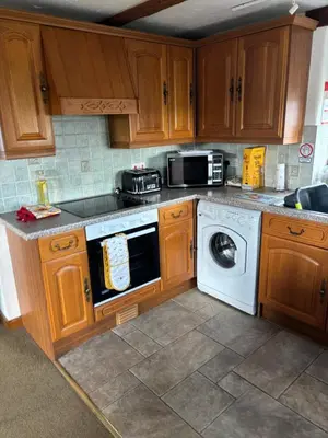 a kitchen with a stove and a dishwasher at Tregatherall Barn in Boscastle