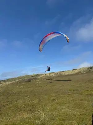 a person is flying a kite in a field at Seaview Caravan, Perran Sands in Perranporth