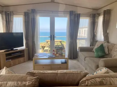 a living room with a view of the ocean at Seaview Caravan, Perran Sands in Perranporth