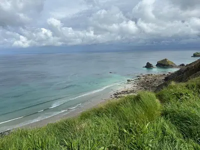 a beach with rocks in the ocean on a cloudy day at Little Nampara Cottage in Portreath