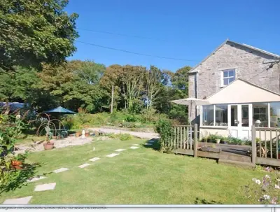 a stone house with a garden and a yard at Little Nampara Cottage in Portreath