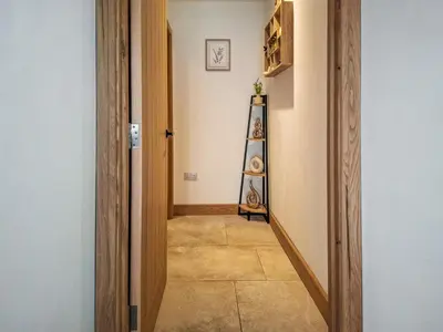 a hallway with a room with a shelf on the wall at The Pines in Redruth