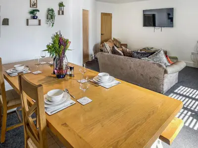 a living room with a wooden table and a couch at The Pines in Redruth