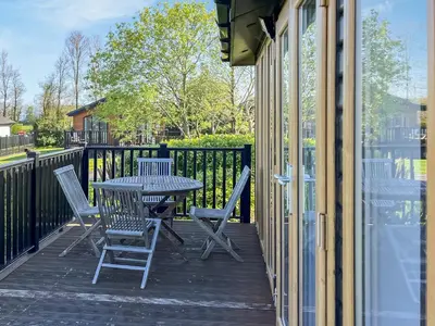 a patio with a table and chairs on a porch at Sunshine Lodge in Polperro
