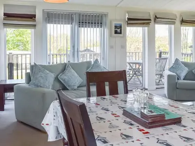 a living room with a table and a couch at Sunshine Lodge in Polperro