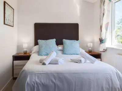 a bedroom with a bed with towels on it at Sunshine Lodge in Polperro