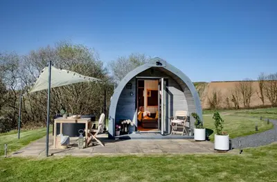 a dome tent with a table and chairs in a field at Demelza in Liskeard