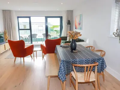 a dining room with a table with chairs and a tableablish at Ebbtide in Newquay