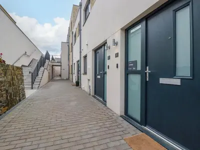 an empty alley with blue doors on a building at Ebbtide in Newquay