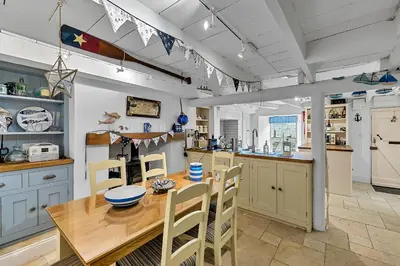 a large kitchen with a wooden table and chairs at Finest Retreats - Garden Cottage in Fowey in Fowey