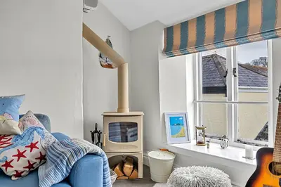a bedroom with a bed and a wood stove at Finest Retreats - Garden Cottage in Fowey in Fowey