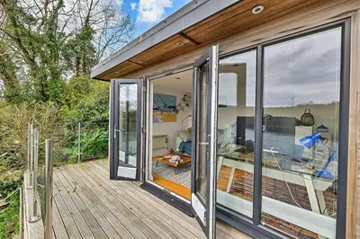 a sliding glass door of a house with a deck at Finest Retreats - Garden Cottage in Fowey in Fowey