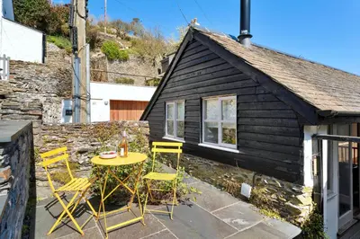 a patio with a table and chairs in front of a house at Finest Retreats - The Old Store in Portloe