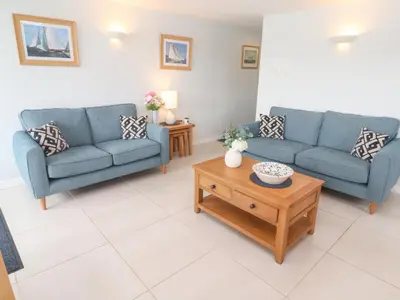 a living room with two blue couches and a coffee table at Tobys Quay in Falmouth