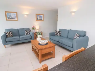 a living room with two blue couches and a coffee table at Tobys Quay in Falmouth