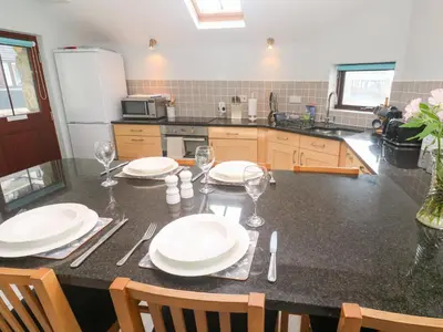 a kitchen with a table with plates and wine glasses at Tobys Quay in Falmouth