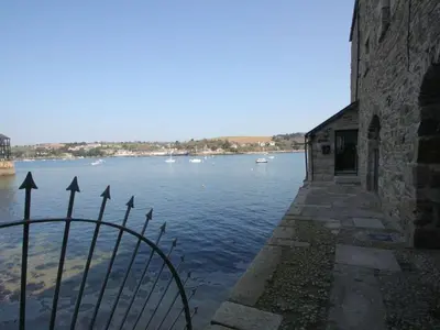 a fence next to a body of water with boats at Tobys Quay in Falmouth