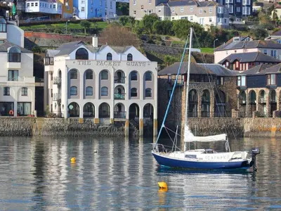 a boat in the water in front of a building at Tobys Quay in Falmouth