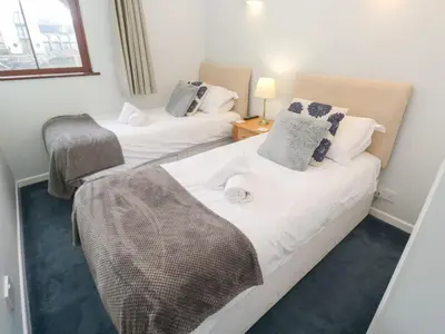 two twin beds in a room with a window at Tobys Quay in Falmouth