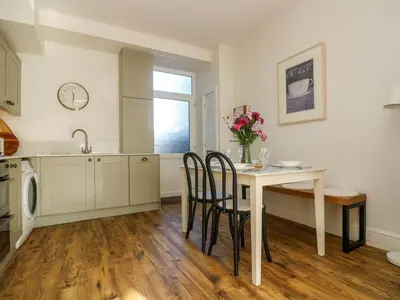 a kitchen with a table and chairs and a sink at Breakers Point in St Ives