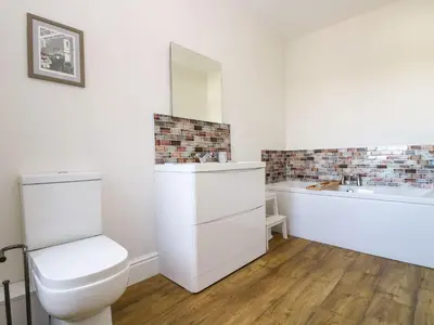 a bathroom with a toilet and a tub and a sink at Breakers Point in St Ives