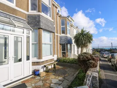 a house with a white door on a street at Breakers Point in St Ives