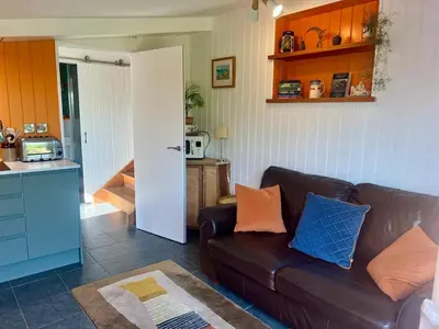 a living room with a couch and a kitchen at The Escape in Crackington Haven