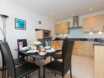 a kitchen with a dining room table with chairs at Skysail in St Ives