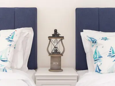a lantern sitting on a night stand between two beds at Skysail in St Ives