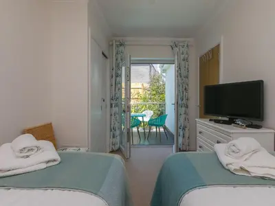a bedroom with two beds and a flat screen tv at Skysail in St Ives