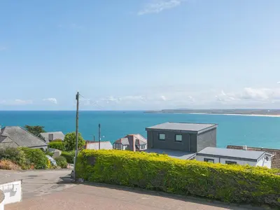 a house on a hill next to the ocean at Skysail in St Ives