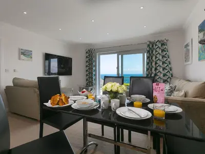 a living room with a table with food on it at Skysail in St Ives