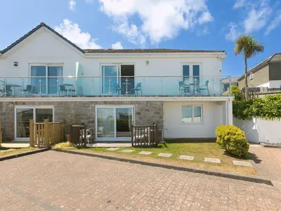 a white house with a balcony on top of it at Skysail in St Ives