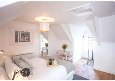 a white living room with a couch and a table at Attic in St Ives