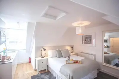 a white bedroom with a bed with a tray on it at Attic in St Ives