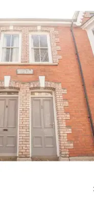 a brick building with a door and two windows at Attic in St Ives