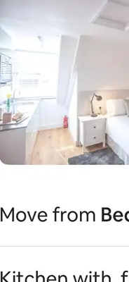 a white bedroom with a bed and a desk at Attic in St Ives