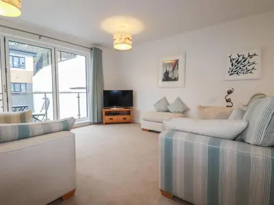 a living room with two couches and a tv at 13 Clock Tower Court in St Austell