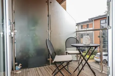 a balcony with a table and chairs on a patio at 13 Clock Tower Court in St Austell