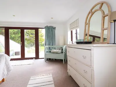 a bedroom with a dresser and a mirror at Goatsland in Wadebridge
