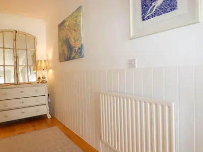 a room with a radiator and a dresser and a mirror at Goatsland in Wadebridge