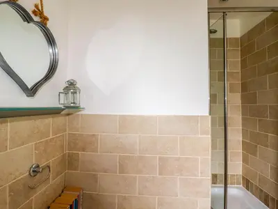 a bathroom with a shower and a tub at Goatsland in Wadebridge