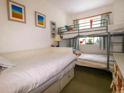 two bunk beds in a room with a window at Goatsland in Wadebridge