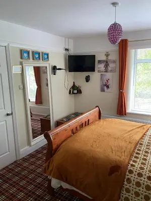 a bedroom with a bed and a mirror at Cornerways Guest House St Austell Cornwall in St Austell