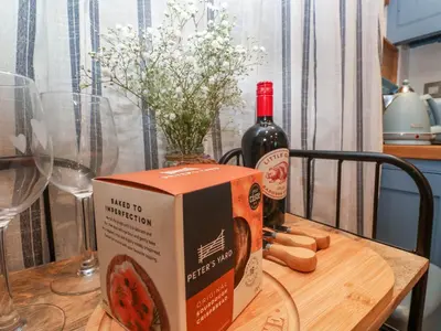 a bottle of wine and a box on a table at Seahorse Cottage in St Ives