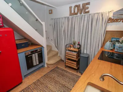 a kitchen with a red refrigerator and a staircase at Seahorse Cottage in St Ives