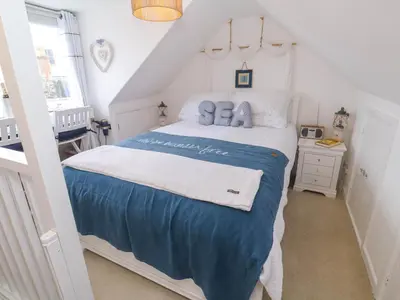 a bedroom with a bed with blue and white sheets at Seahorse Cottage in St Ives