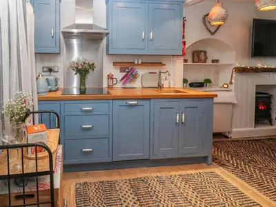 a kitchen with blue cabinets and a sink at Seahorse Cottage in St Ives