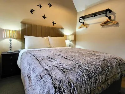 a bedroom with a bed with birds on the wall at 2 bed barn on smallholding in Stithians